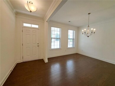 Foyer with ornamental molding, and dark wood-style floors