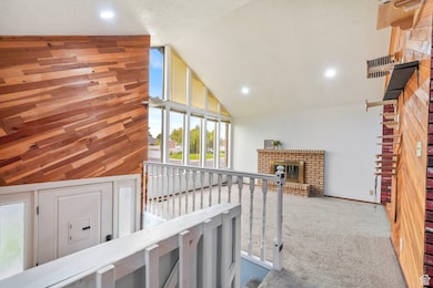 Living Room featuring a fireplace, wooden walls, carpet floors, high vaulted ceiling, and recessed lighting