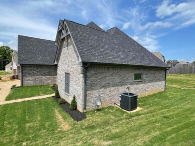 View of side of property featuring brick siding, a lawn, and a shingled roof