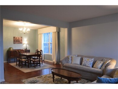 living room open to dining room with hardwood floo