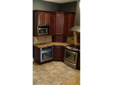Cherry cabinets, granite counters, inlaid tile flo