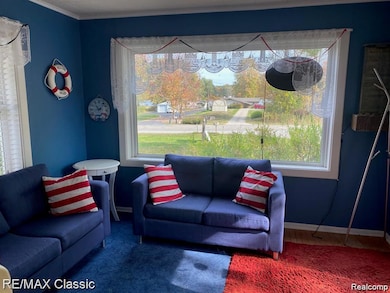 Living area featuring baseboards and ornamental molding