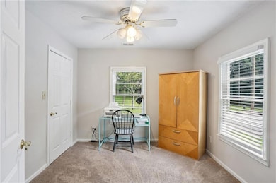 Office area with light colored carpet and ceiling fan