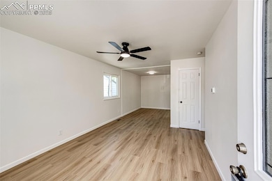 Empty room with light wood-type flooring, baseboards, and ceiling fan