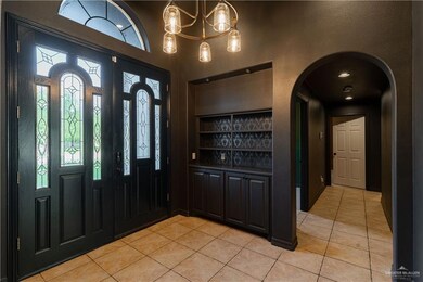 Foyer with light tile patterned flooring and arched walkways