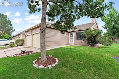 Single story home with an attached garage, driveway, a front lawn, and a chimney