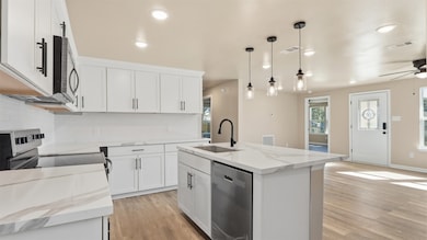 View from the kitchen looking into the bright and open living space, highlighting the stunning natural light and elegant quartz countertops.