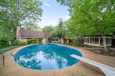 Outdoor pool with a sunroom and a diving board