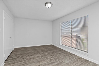 Spare room with dark wood-type flooring and a textured ceiling