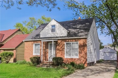 Cape cod-style house featuring garage and a front lawn