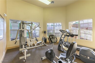 Gym featuring a towering ceiling and baseboards
