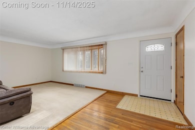 Foyer with light wood-style floors and baseboards
