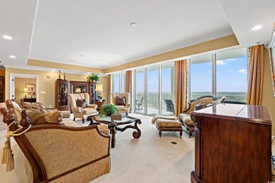 Carpeted living room with a tray ceiling and ornam