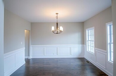 Formal Dining Room with Hardwood Flooring and Wainscoting