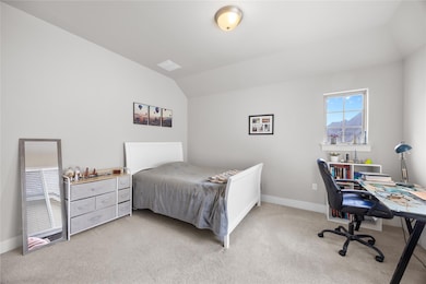 Bedroom with light carpet, baseboards, and vaulte