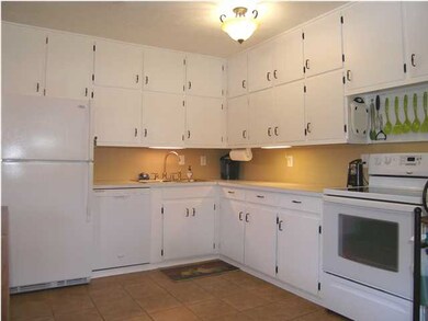 The applianced kitchen offers lots of pristine whi