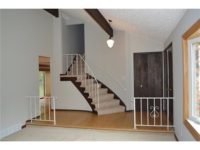 Large foyer with beamed ceiling and curved stairca