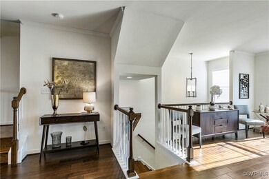 Corridor with ornamental molding and dark hardwood