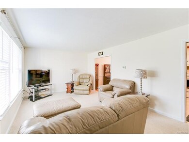 The living room features carpet and a large picture window.