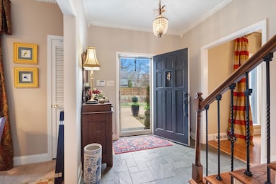 Foyer featuring baseboards, ornamental molding, an