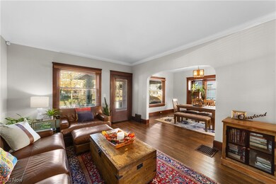 Living room with dark hardwood / wood-style flooring and crown molding