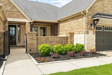 Boasting colorful landscaping and a wrought iron gate to access the Courtyard, the Front Porch awaits those who want to enjoy the privacy and security provided here. Notice the design elements that connect the stone and brick and the use of wooden columns to bring in components of nature.