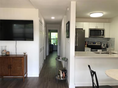 Kitchen featuring a sink, white cabinetry, applia