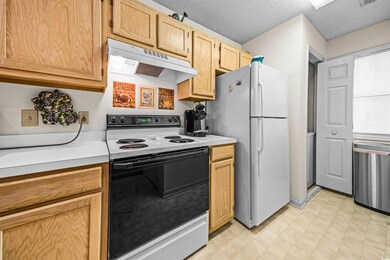 Kitchen with light brown cabinets, white appliance