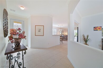 Entryway and hallway with crown molding, light til