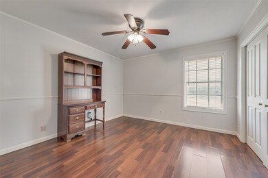 Unfurnished bedroom featuring crown molding, dark wood-style floors, ceiling fan, and a closet