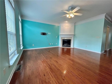 Unfurnished living room featuring crown molding, a