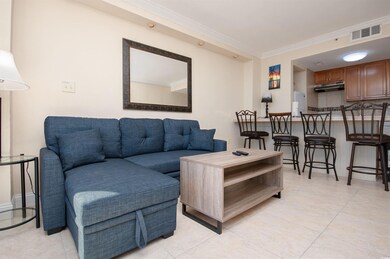 Living area featuring light tile patterned floors and crown molding