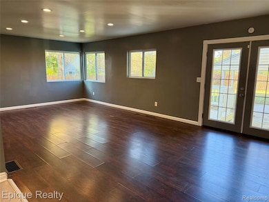 Spare room with dark wood-style floors, french doors, and recessed lighting