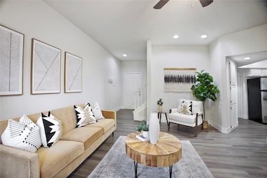 Living room featuring recessed lighting, dark wood-style floors, a ceiling fan, and stairway