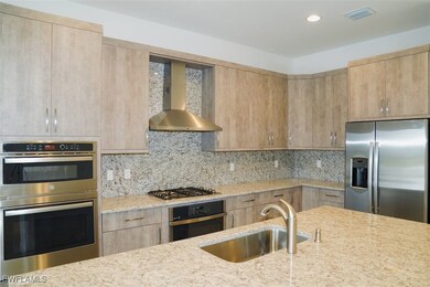 Kitchen featuring wall chimney exhaust hood, sink,