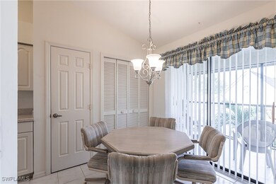 Tiled dining room featuring vaulted ceiling and a