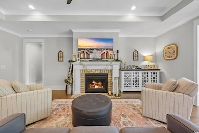 Living area featuring wood finished floors, a fireplace, recessed lighting, and crown molding