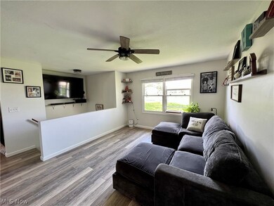 Living room with ceiling fan and hardwood / wood-style floors
