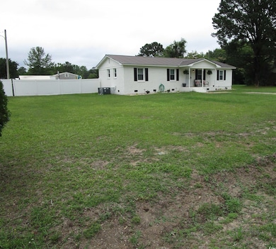 Back of house featuring crawl space, central AC unit, a porch, and metal roof