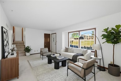 Living room featuring light colored carpet, clean white walls, and wood trim