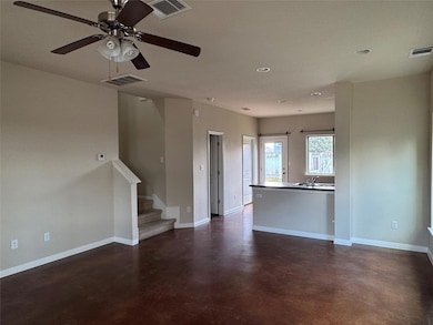Unfurnished living room with finished concrete floors, a ceiling fan, stairs, and recessed lighting