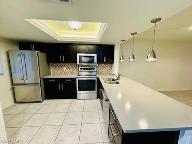 Kitchen featuring pendant lighting, a raised ceili