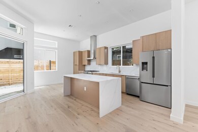 Kitchen with a center island, appliances with stainless steel finishes, light countertops, light wood-style floors, and modern cabinets