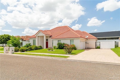 Mediterranean / spanish home with a tile roof, concrete driveway, a garage and gate