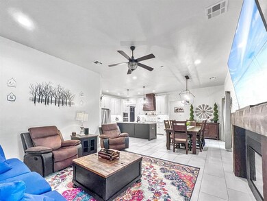 Living room with ceiling fan, light tile patterned flooring, recessed lighting, and a fireplace