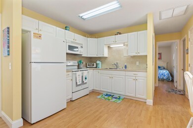 Kitchen with white cabinets, white appliances, lig