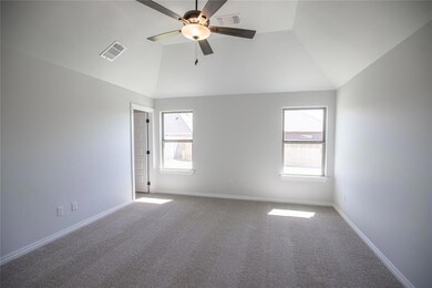 Empty room featuring carpet floors, vaulted ceilin