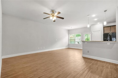 Unfurnished living room featuring light wood-style floors, a ceiling fan, and recessed lighting