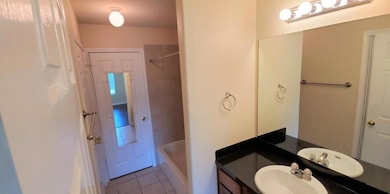 Full bathroom with tile patterned floors, vanity,