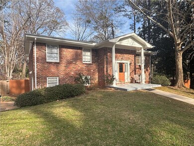 Raised ranch with brick siding, a front lawn, and 